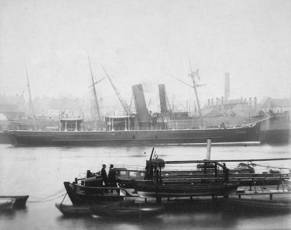 Two steamships with tall funnels and masts moored at Manor Quay on the River Wear, with small boats and chimneys in the mist behind.